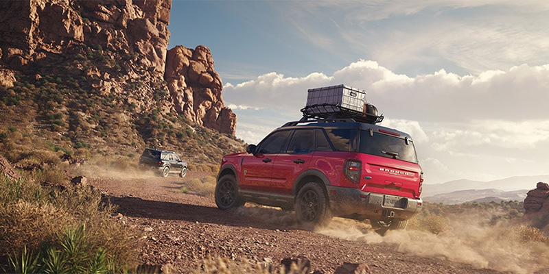 2025 Ford Bronco Sport in red driving off-road through rocky desert terrain, showcasing rugged adventure capability and performance.